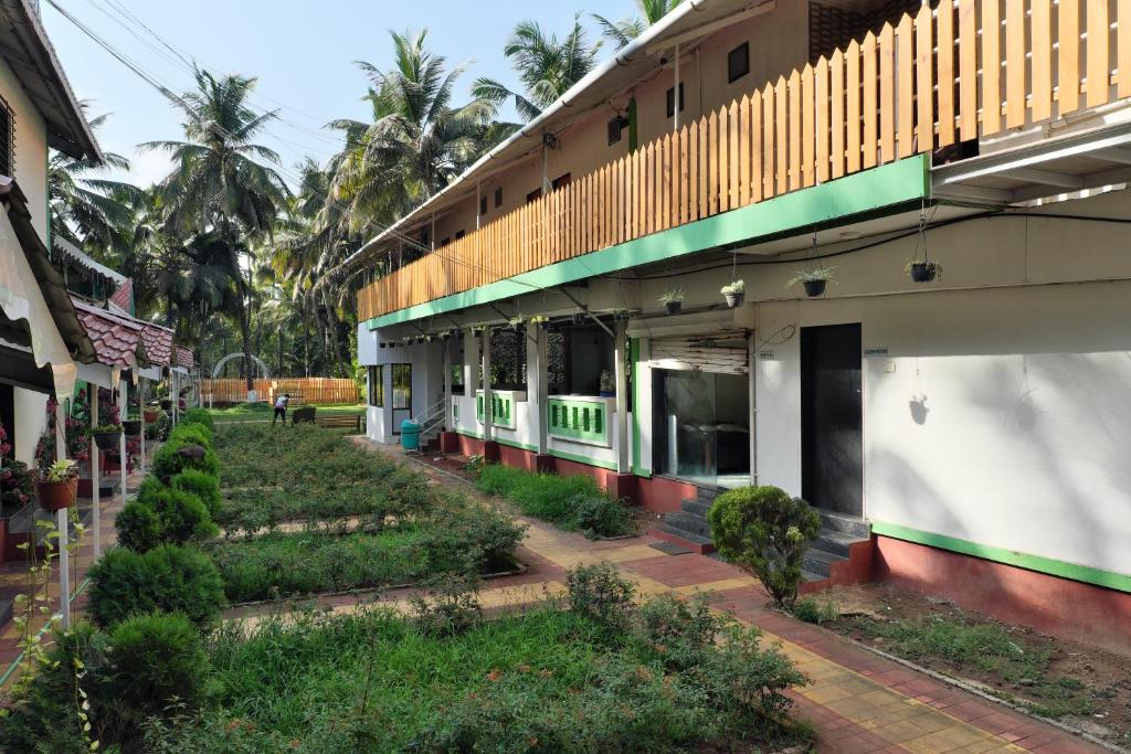 a building with a garden in front of it at Betel Leaf Resort in Māhīm