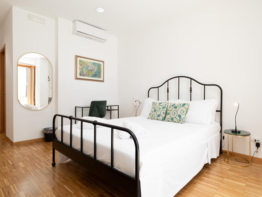 a bedroom with a large white bed and a mirror at Dadu 14 in Bari