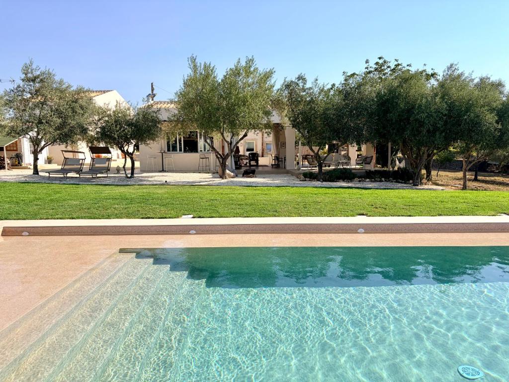 a swimming pool in front of a house at La Dimora del Pensatore - country escape Noto in Canicattini Bagni
