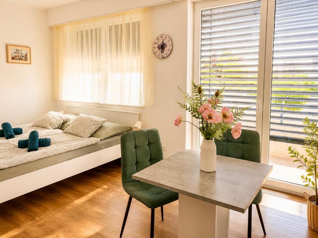 a living room with a bed and a table and chairs at TRIO apartment in Piešťany