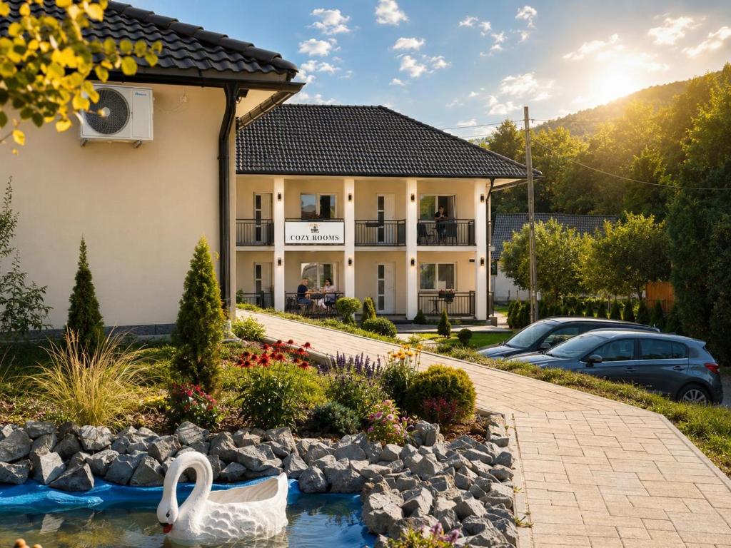 a house with two swans in a pond at Cozy Rooms in Praid