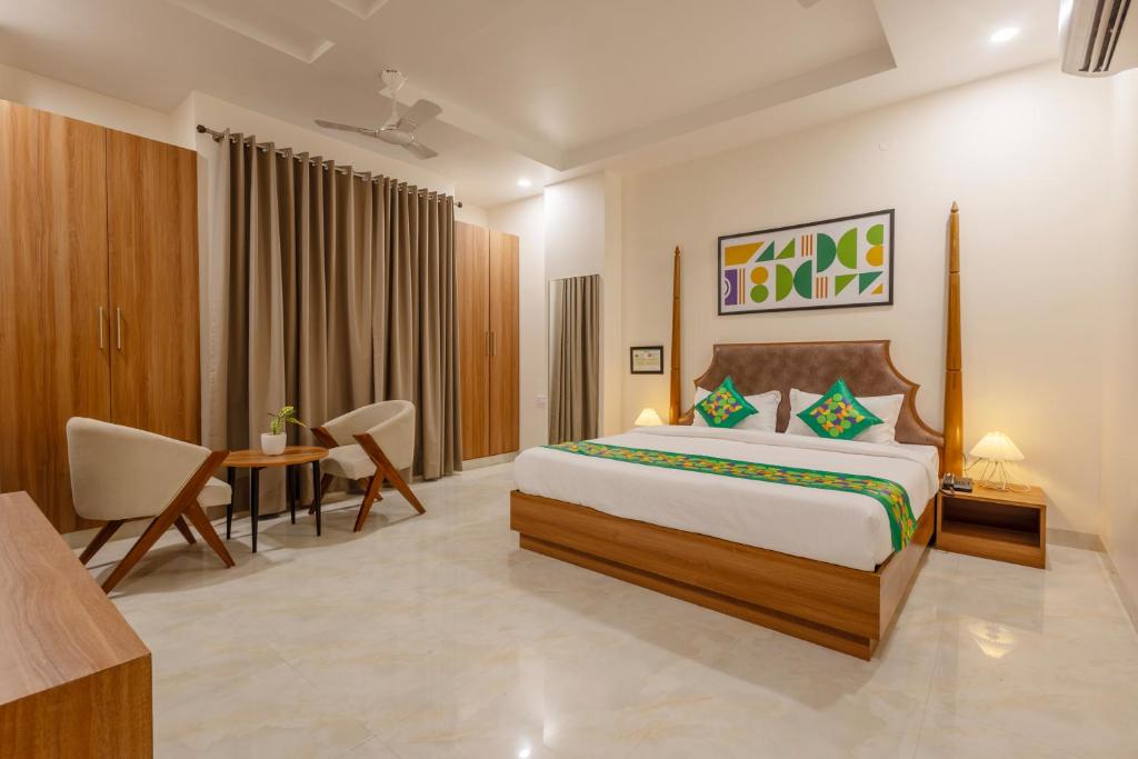 a hotel room with a bed and a table and chairs at Treebo Premium The Maulshri, Behind Health Vistaar City in Lucknow