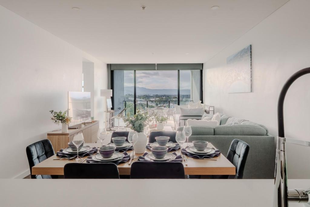 a living room with a table and chairs and a couch at On Flinders Wollongong in Wollongong