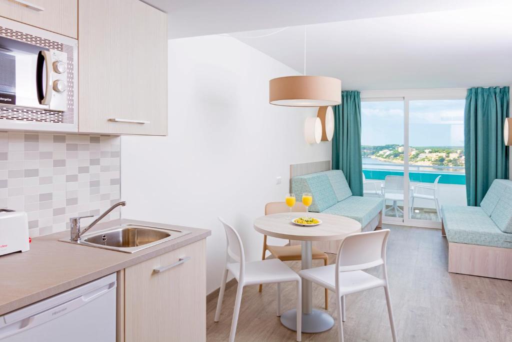 a kitchen and living room with a table and chairs at HSM Sandalo Beach in Magaluf