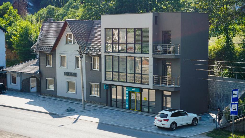 a white car parked in front of a house at Synyogora in Yaremche