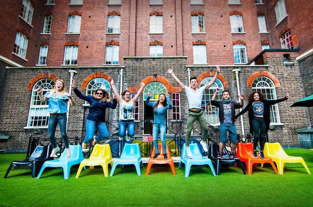 a group of people standing on chairs in front of a building at Rest Up London in London