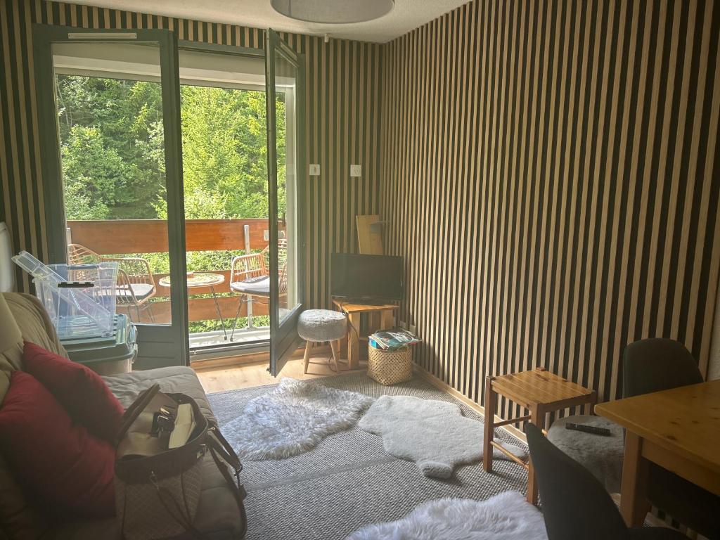 a living room with a couch and a sliding glass door at B&B cot in La Ferrière
