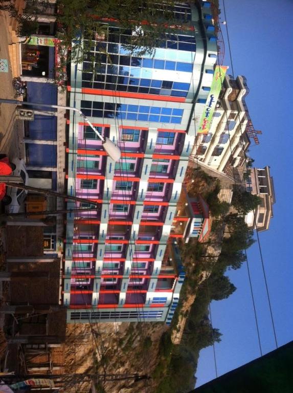a tall building with red white and blue windows at Moon Palace by MZ Hotels Pakistan KPK in Mingāora