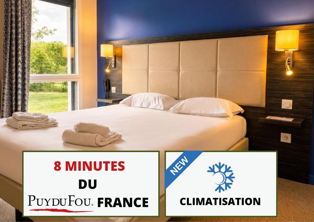 a hotel room with a bed with towels on it at The Originals City, Hôtel La Verriaire, Cholet Sud in La Verrie