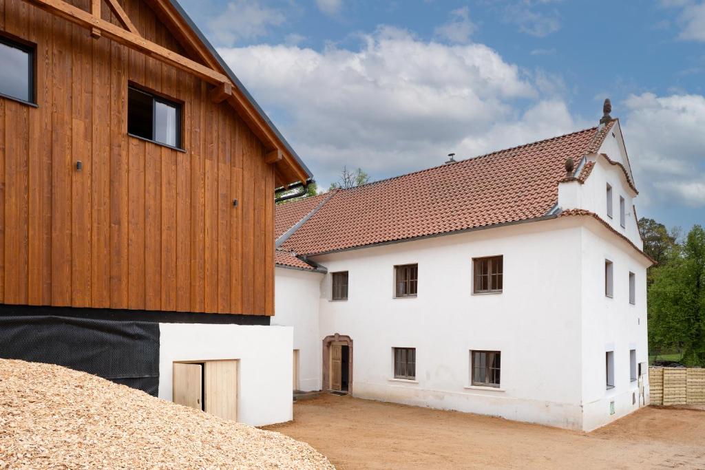 a large white house with a wooden roof at Mlýn Propast in Stříbrná Skalice