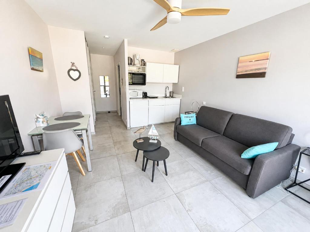 a living room with a couch and a table at Studio rez-de-jardin la Baule proche centre Pornichet in La Baule