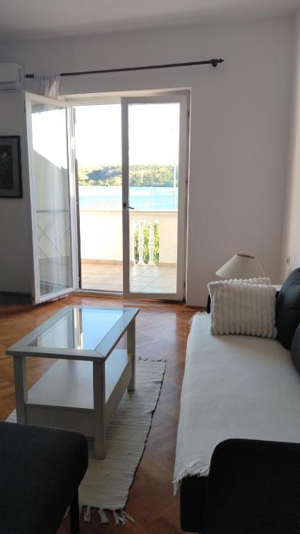 a living room with a couch and a glass table at Apartment Školj in Posedarje