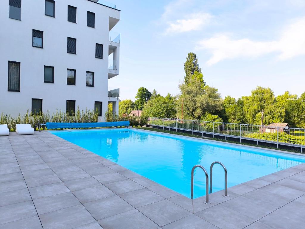 a swimming pool in front of a building at Helikon Terasz Apartman in Keszthely