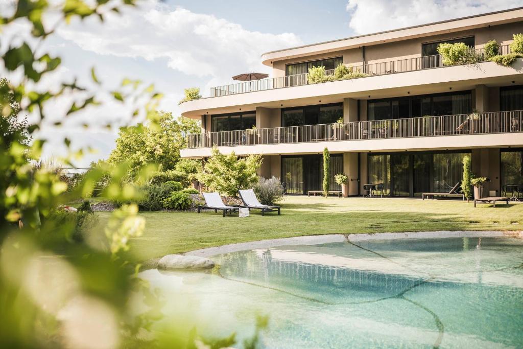 a building with a swimming pool in front of it at Belia Lofts - ADULTS ONLY - Apartments in Appiano sulla Strada del Vino