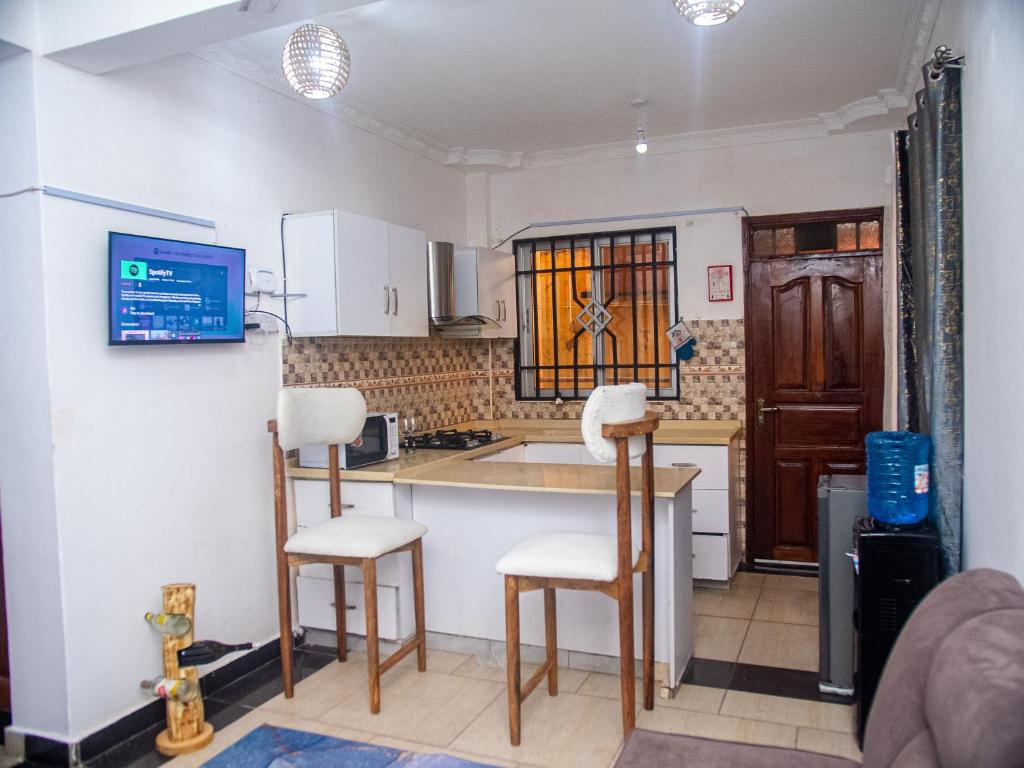 a kitchen with a counter and chairs in a room at Queen Tori in Malindi