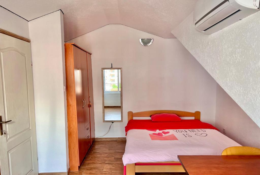 a small bedroom with a bed with a red blanket at Homestay Mark - DOUBLE BED ROOM - shared bathroom in Budva
