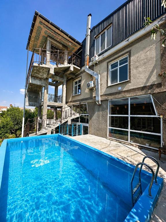 a large blue swimming pool in front of a building at Гостевой дом Sartepo in Samarkand