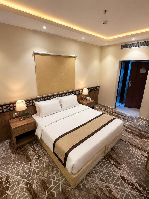 a bedroom with a large white bed in a room at فندق جوهرة الحجاز توصيل من والى الحرم مجاناً in As Sifyānī