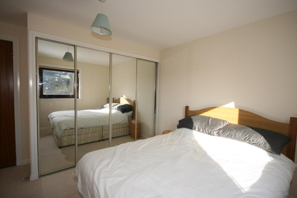 a bedroom with a large mirror and a bed at Glasgow West End Accommodation in Glasgow