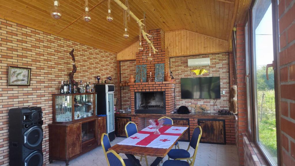 a dining room with a table and a television in a house at Rokiti Yard in Bagdatʼi
