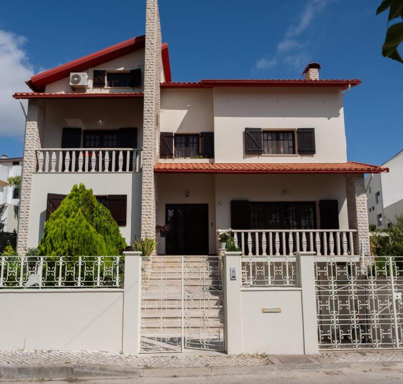 a white house with a gate in front of it at Telesico Residencia in Pombal