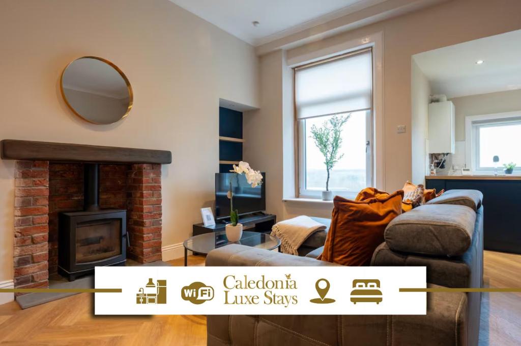 a living room with a couch and a fireplace at Station Road Stays in Kirk of Shotts