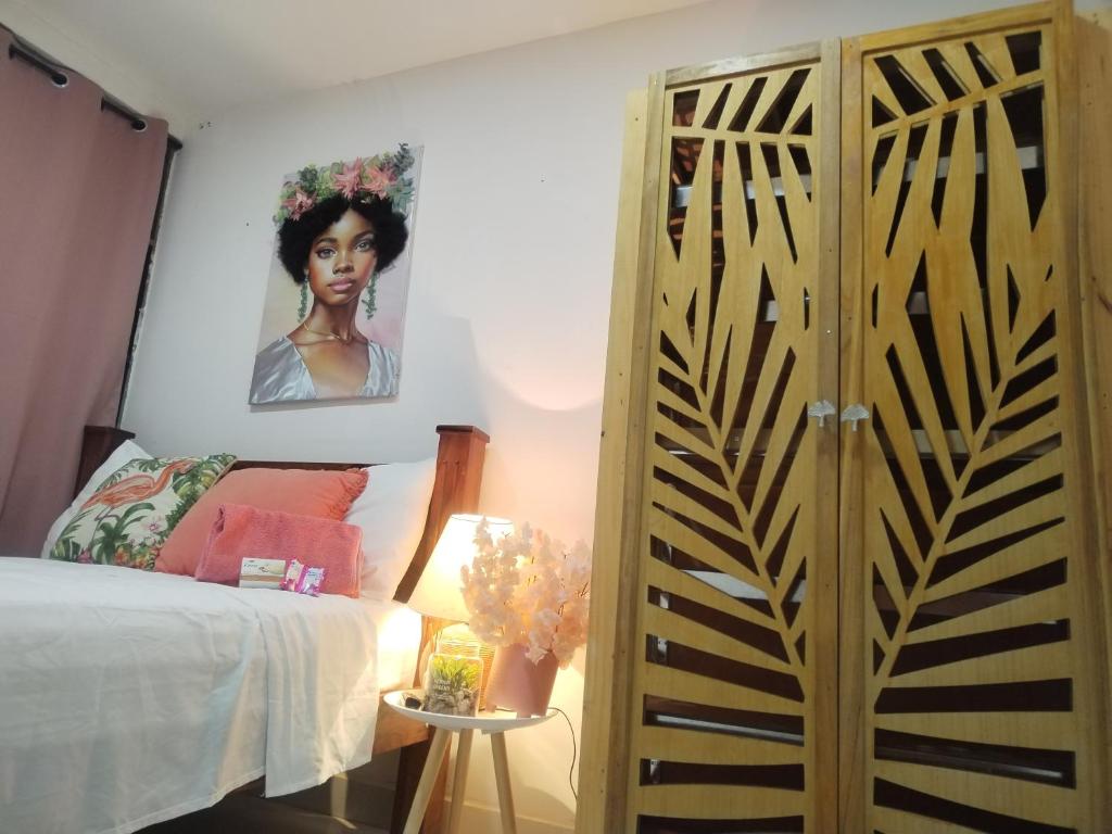 a bedroom with a bed and a painting on the wall at Carribean Boutique Hostel in San José