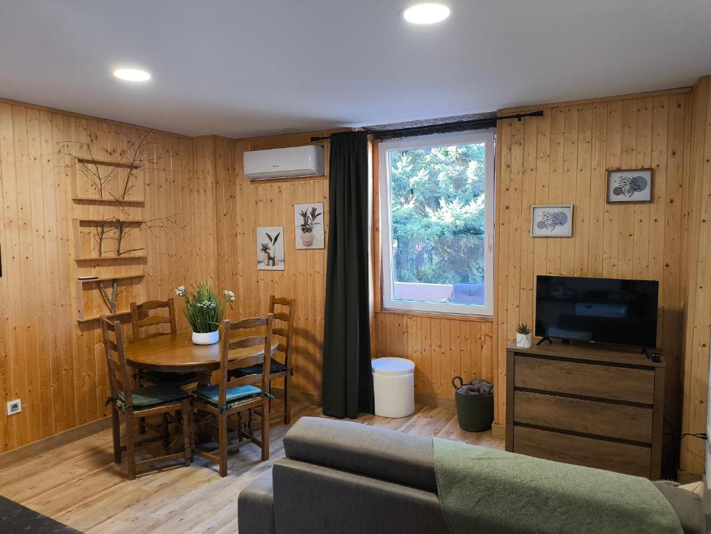 a living room with a couch and a table and a television at Casa Wood in Guarda