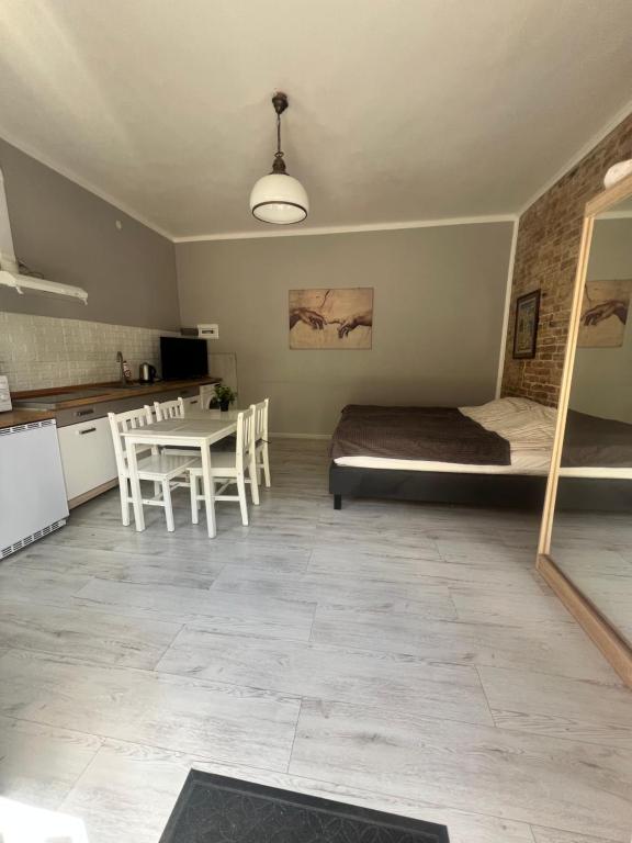 a bedroom with a bed and a table and a kitchen at Louis Apartaments Kostrzyn in Kostrzyn nad Odrą