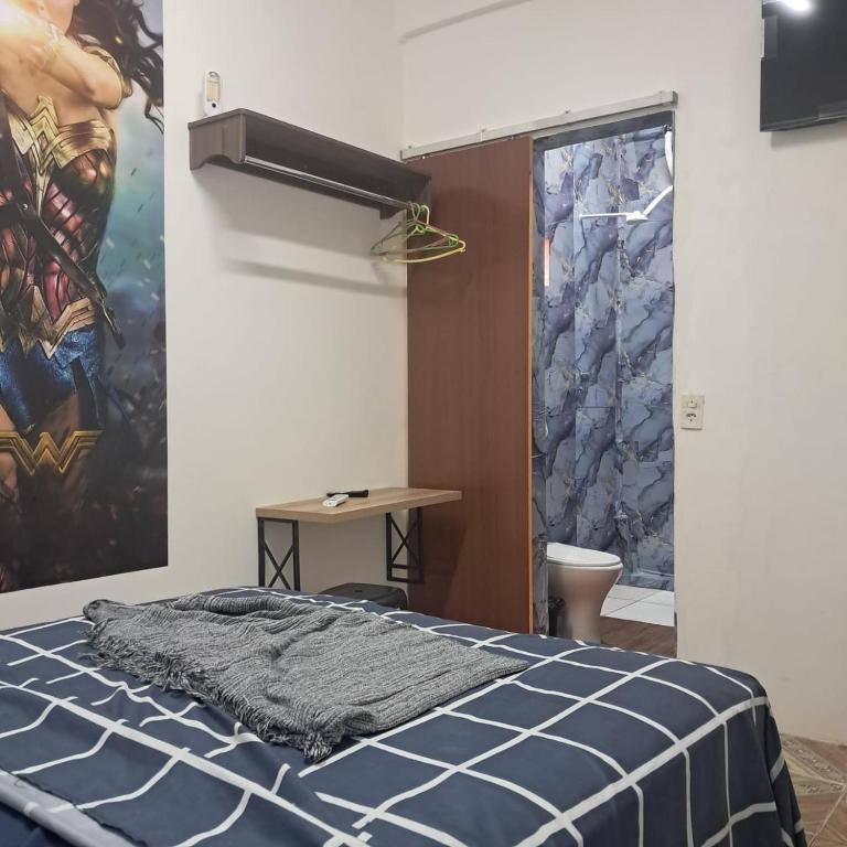 a bedroom with a bed and a painting on the wall at Bem no Centro in Juazeiro do Norte