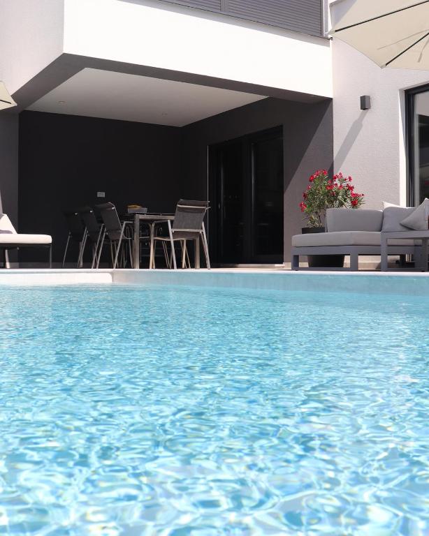a swimming pool with chairs and a table at Luxury Villa Meerbrise - Private Pool - Near Medulin, Kamenjak, Pola in Banjole