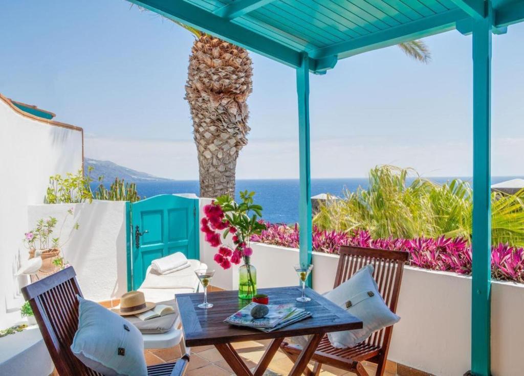 a table and chairs on a patio with a palm tree at Apartamentos Cancajos in Los Cancajos