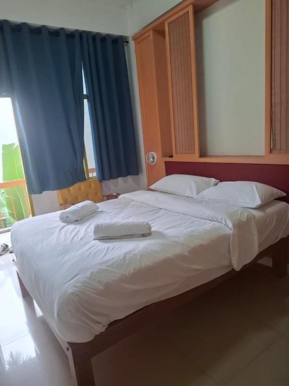 a large bed with two towels on top of it at Happy 2 Pratunam Hotel in Bangkok