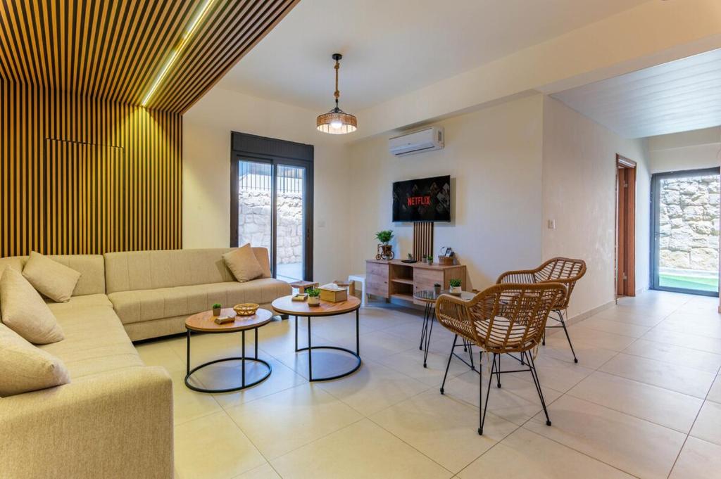 a living room with a couch and a table and chairs at Echo 1-BR Apartment In Ejdabra Batroun 