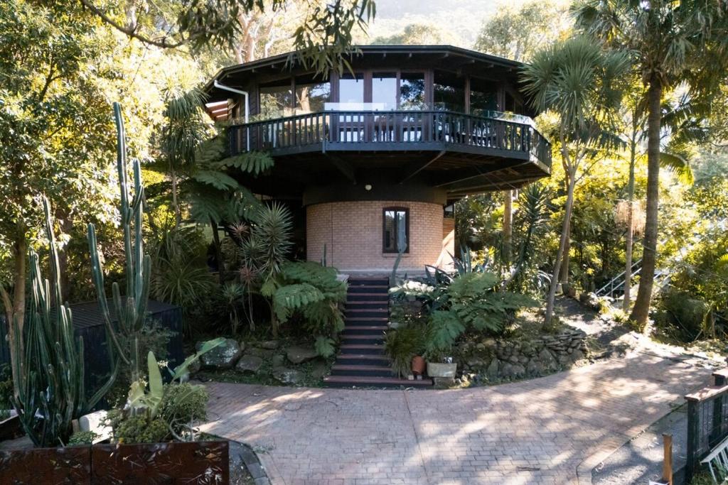 a house with a balcony on top of it at The Graceful Dodeca Treehouse Coalcliff 