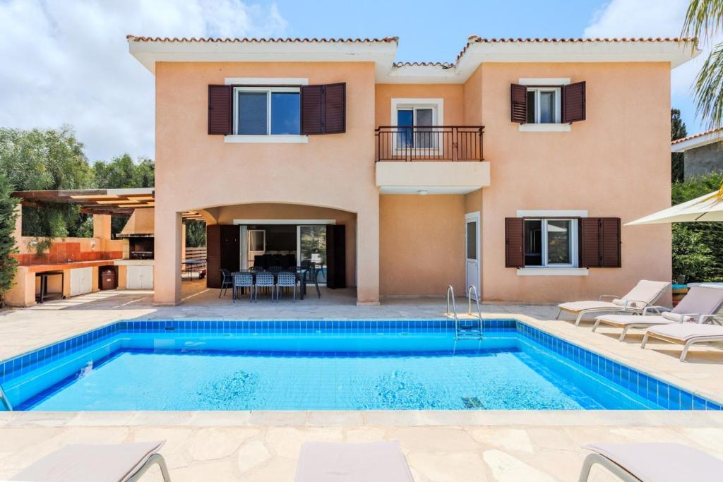 a villa with a swimming pool and a house at Villa Isla in Peyia
