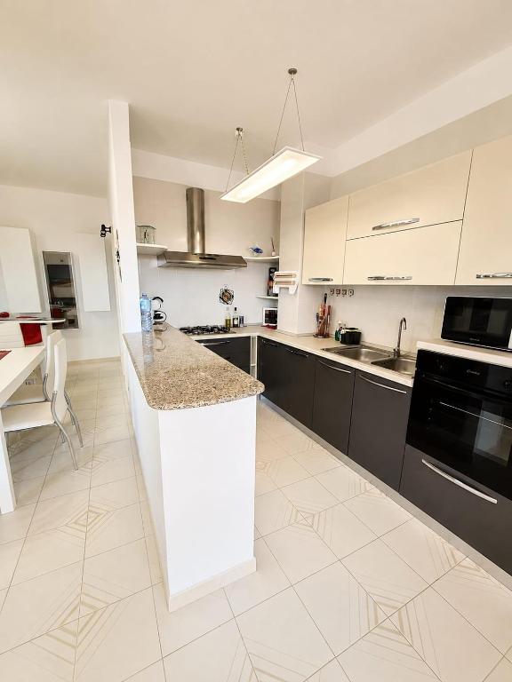 a large kitchen with white cabinets and a counter at Lello's Dream House in Càbras
