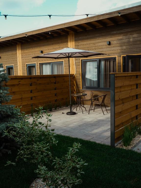 a patio with an umbrella and a table and chairs at Sunrise Hotel in Kyiv