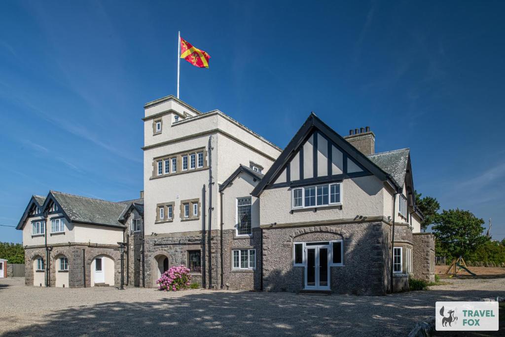 a building with a flag on top of it at The Plas - Rhosneigr Manor House in Rhosneigr