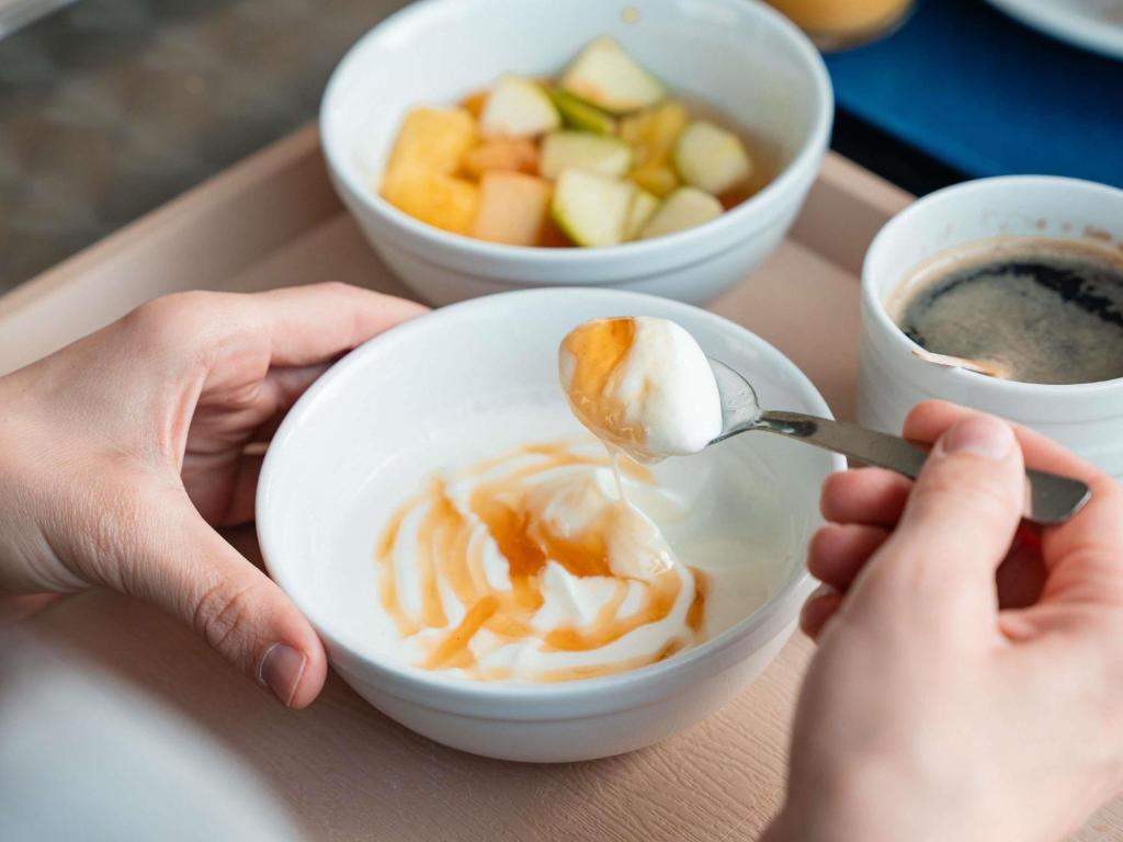 a person is eating a bowl of food with a spoon at ibis budget Narbonne Est in Narbonne