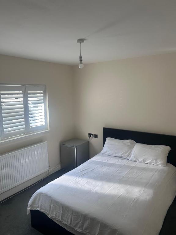 a bedroom with a white bed and a window at Double Room Private Bathroom Parking South Croydon in Addington