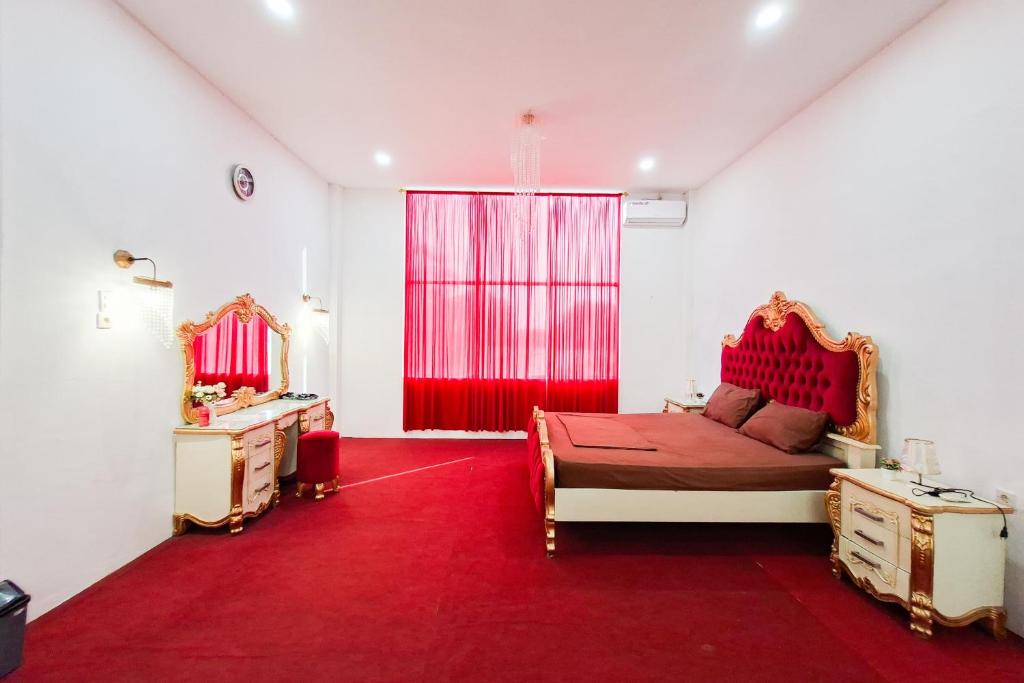 a bedroom with a red bed and a red carpet at RedDoorz at Pasifik Hotel Sabang Aceh in Sabang