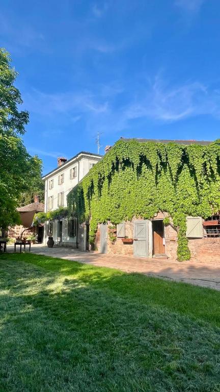 a building covered in green ivy next to a park at Il Casale di Bubu in Modena
