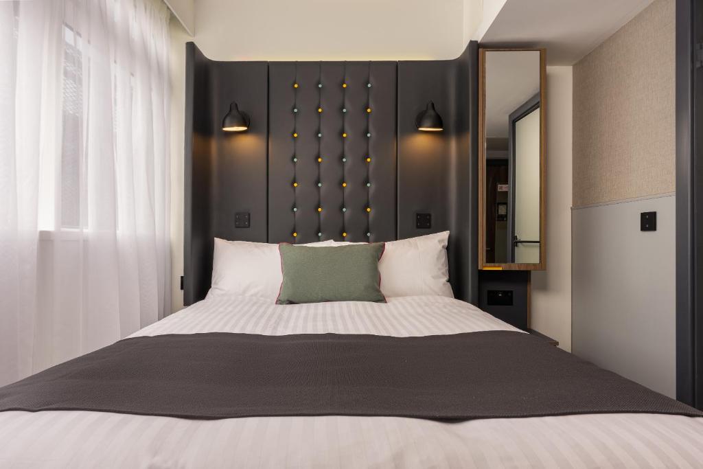 a bedroom with a large bed with a black headboard at Point A Hotel Edinburgh St Andrew Square in Edinburgh