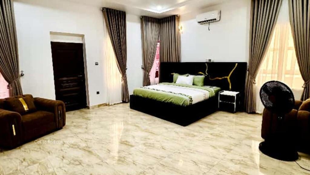 a bedroom with a bed and a couch in a room at Julaz Apartment in Lagos