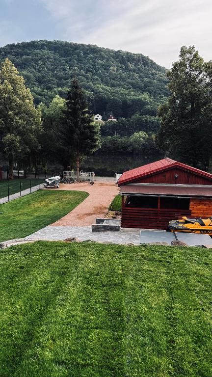 a building with a red roof and a grass field at Chata u Zajpta in Ústí nad Labem