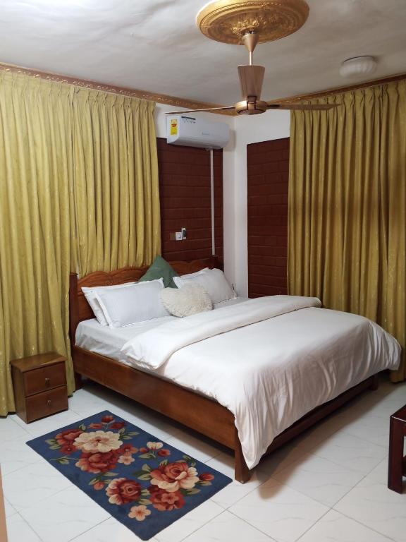 a bedroom with a large bed and a ceiling at Sunset Banana Beach Resort in Prampram