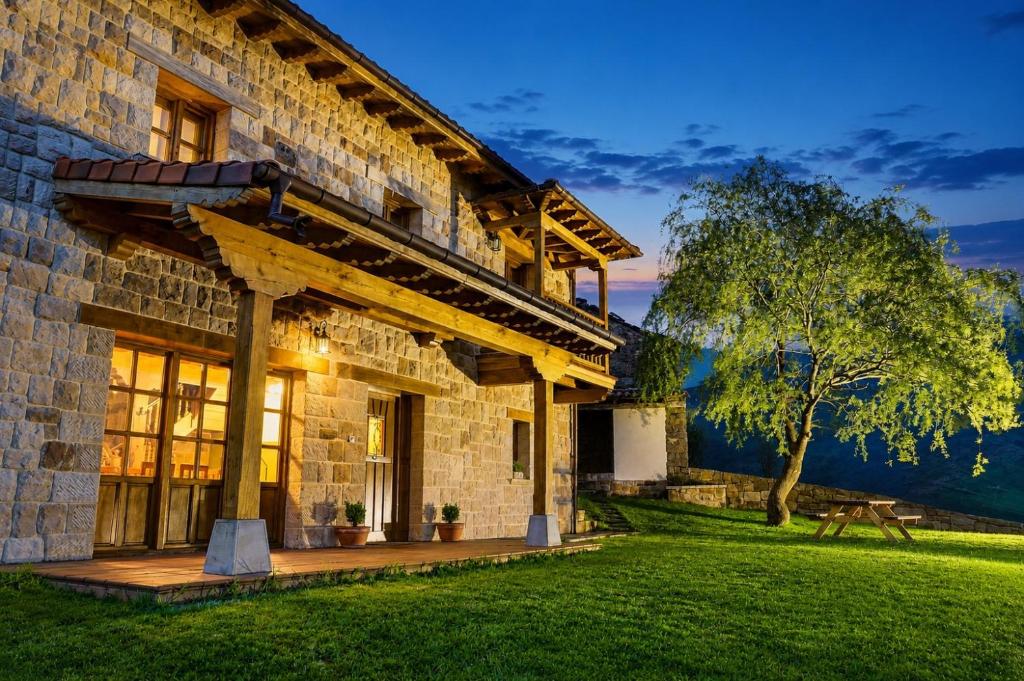 a large stone house with a green lawn at La Casa de Bustantegua in Selaya