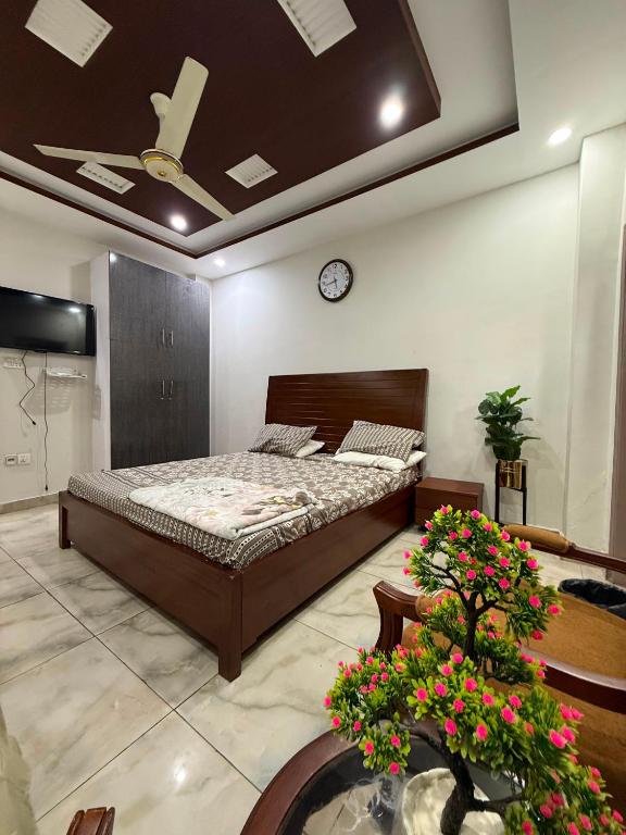 a bedroom with a bed and a clock on the ceiling at Khushal Residence in Peshawar