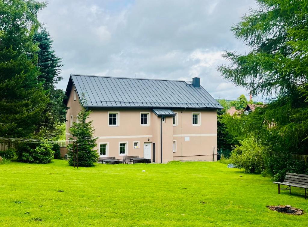 a large white house with a green yard at Chalupa Měděnecká in Kovářská